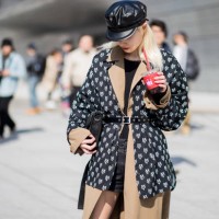 Guest wearing flat cap, belted trench and belted jacket with print is seen at the Hera Seoul Fashion Week 2018 F/W at Dongdaemun Design Plaza on...