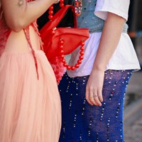 Guest wearing white tshirt, blue corset, denim beaded skirt and red bag during Australian Fashion Week Presented By Pandora 2024 at Carriageworks on...