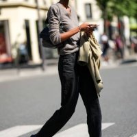 Guest wears a beige wool pullover, a black shiny leather shoulder bag, a beige blazer jacket, black denim large pants, black suede and fabric...