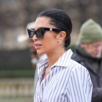 Guest wears a black and white striped shirt, Off-White sunglasses, earrings, outside Off-White, during the Womenswear Fall/Winter 2024/2025 as part...