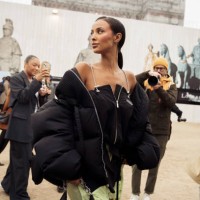 Guest wears a black mini dress with green details and black bag outside Off-White during the Womenswear Fall/Winter 2024/2025 as part of Paris...