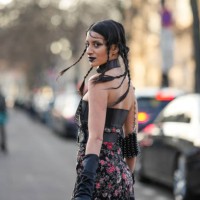 Guest wears a black shiny leather large nailed / studded belted top, a black with embroidered red and pink flower pattern shoulder-off / long dress,...