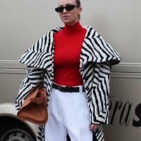 Guest wears a Black & White Animal Print Coat with a Red Polo Neck Jumper at OpéraSport, during the Copenhagen Fashion Week Autumn/Winter 2025 on...