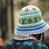 Guest wears a black with neon blue and green embroidered pattern polo shirt, a white / blue / green striped print pattern with embroidered LV black...