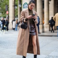 Guest wears a brown trench coat, a brown top with leopard patterns, a dark brown / burgundy leather skirt, a black leather bag, black leather boots,...