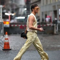 Guest wears a cream-color full look, a waist coat, flared lustrous pants, blue flat shoes, outside Alice & Olivia, during New York Fashion Week, on...