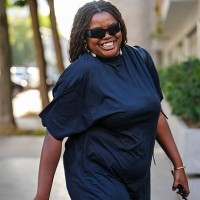 Guest wears a dark navy, short-sleeved dress with a relaxed fit. The dress appears to be made of a lightweight fabric. Sunglasses from Balenciaga...