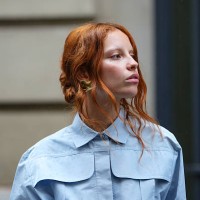 Guest wears a full Patou outfit with a light blue button-up shirt with a structured collar and oversized chest pockets. Hair is styled in loose...