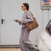 Guest wears a gray wool jacket, brown leather Gucci bag, long gray wool skirt, gray kitten heels, outside Jil Sander, during the Milan Fashion Week...
