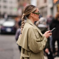 Guest wears a green Prada sunglasses, a beige trench coat, outside La Pointe , during New York Fashion Week, on February 10, 2024 in New York City.