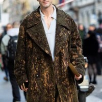 Guest wears a grey hat, a white shirt, military green trouser and a green and beige knitted long coat outside Pierre-Louis Mascia show during the...