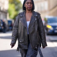 Guest wears a grey leather oversized biker jacket, a white top, grey wide-leg cargo denim pants, outside Marine Serre, during the Womenswear...