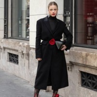 Guest wears a long black coat, black turtleneck top, red shoes, leggings and black bag outside Magda Butrym during the Womenswear Fall/Winter...