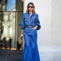 Guest wears a long blue denim dress, a black leather belt, a gold bag, sunglasses, outside Zimmermann, during the Womenswear Fall/Winter 2024/2025 as...