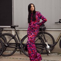 Guest wears a long maxi dress in purple, red, and pink color combination outside Gestuz during the Copenhagen Fashion Week Spring/Summer 2024 on...