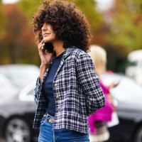 Guest wears a navy blue top, a black and white checkered Chanel jacket, blue denim pants, outside Chanel, during Paris Fashion Week - Womenswear...