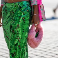 Guest wears a neon pink and green striped print pattern jacket, a silver chain bracelet, silver rings, green sequined with black and gold small...