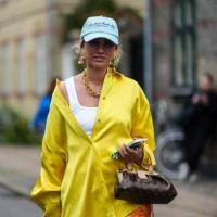 Guest wears a pale blue denim with embroidered navy blue inscriptions pattern cap, glasses, gold large pendant earrings, a gold large chain necklace,...