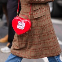 Guest wears a red heart-shaped bag with the written inscription 