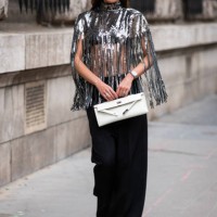Guest wears a silver fringed sequins top, black pants, white bag, outside Hermes, during Paris Fashion Week - Womenswear Fall Winter 2023 2024, on...