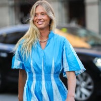 Guest wears a silver pearls necklace, a blue and pale blue print pattern / flared short sleeves / long dress, silver rings, outside Baum und...