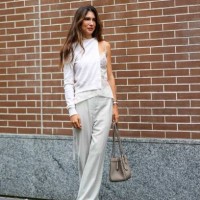 Guest wears a white cardigan, a white lace strappy lingerie top, white long pants, a light brown ba, outside Fendi, during the Milan Fashion Week -...