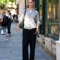 Guest wears a white shirt, light gray button up cardigan sweater, dark green Bottega Veneta leather bag, black loose pants, black sheer mesh flat...