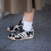 Guest wears Adidas sneaker with animal cow print outside Lueder during Berlin Fashion Week SS26 on July 02, 2025 in Berlin, Germany.