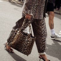 Guest wears animal print pants, animal print jacket and animal print bag outside the Gestuz show during day four of the Copenhagen Fashion Week SS25...