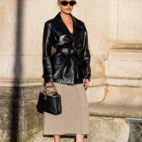 Guest wears belted leather jacket, beige skirt, bag, sunglasses outside Louis Vuitton during Womenswear Spring/Summer 2025 as part of Paris Fashion...