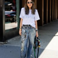 Guest wears black Balenciaga bag, denim jeans with print, white shirt outside Brandon Maxwell during New York Fashion Week on September 06, 2024 in...