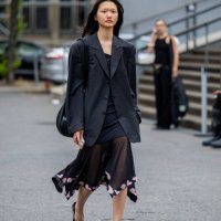 Guest wears black blazer, transparent skirt outside Lueder during the Berlin Fashion Week SS25 on July 01, 2024 in Berlin, Germany.