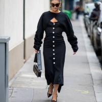 Guest wears black button up dress, cut out jumper, bag outside Valentino during the Womenswear Fall/Winter 2024/2025 as part of Paris Fashion Week on...