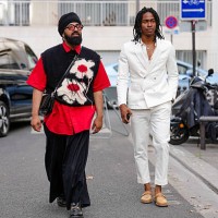 Guest wears black framed sunglasses, head scarf, bright cherry red short sleeve shirt, black knit cream cherry red floral pattern sweater vest, shiny...