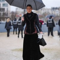 Guest wears black high neck long sleeve shirt, silver necklace, burgundy black tailored velvet butterfly embroidered Dior blazer jacket, black maxi...