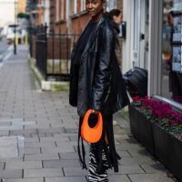 Guest wears black leather jacket, zebra print boots, orange Coperni bag outside Bora Aksu during London Fashion Week February 2024 on February 16,...