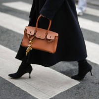 Guest wears black pointed toe heels boots, a shiny dark brown Hermes leather bag, outside Miss Sohee, during the Haute Couture Spring/Summer 2025 on...