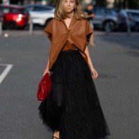 Guest wears black skirt, brown leather shirt, red bag outside Baum & Pferdgarten during day three of the Copenhagen Fashion Week SS25 on August 07,...