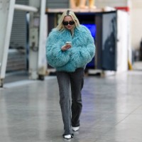 Guest wears black sunglasses, a blue faux fur fluffy jacket, black denim jeans / pants, white leather pointed shoes, outside BlueMarble, during the...