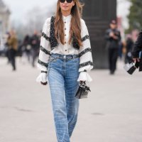 Guest wears black sunglasses, silver earrings, white buttoned up long sleeve black lace striped pattern shirt, black sequin embroidered vest, silver...