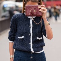 Guest wears blue tweed chanel cardigan, blue tweed pants, burgundy Chanel bag, outside Chanel, during the Womenswear Fall/Winter 2024/2025 as part of...