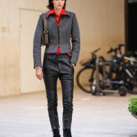 Guest wears bright red buttoned up long sleeve shirt, dark gray tailored jacket, dark brown leather bag, shiny black skinny leather jeans, black gray...