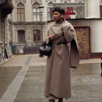 Guest wears brown coat, brown shoes, and a black bag outside Aeron during the Copenhagen Fashion Week AW24 on January 30, 2024 in Copenhagen, Denmark.