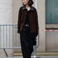 Guest wears brown jacket with leather collar, black trousers, yellow sneakers, outside Miu Miu, during the Womenswear Fall/Winter 2025/2026 as part...