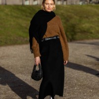 Guest wears brown knit, black scarf, black bag, high waisted shirt, white socks, heels outside Marimekko during the Copenhagen Fashion Week AW24 on...