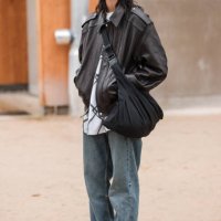 Guest wears brown leather jacket, baggy jeans, blue hat, leopard print flat shoes, outside Chanel, during the Haute Couture Spring/Summer 2024 as...