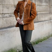 Guest wears brown suede jacket, dark grey jeans, black sunglasses, outside Nina Ricci, during the Womenswear Fall/Winter 2025/2026 as part of Paris...