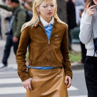 Guest wears brown suede jacket, vinyl skirt, blue blouse outside Miu Miu during the Womenswear Fall/Winter 2025/2026 as part of Paris Fashion Week on...