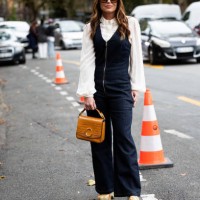 Guest wears brown sunglasses, a white shirt, a blue jeans denim jumpsuit, beige mules and a brown leather Chloé bag outside Chloé show during...