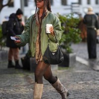 Guest wears brown sunglasses, gold chains pendant necklaces, a brown shirt from Munthe, a green oversized bomber coat, a black nylon handbag from...